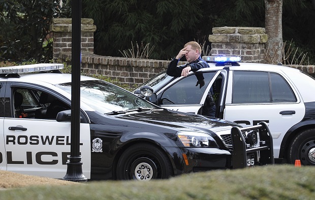 Roswell Police officers stand guard while blocking the street to the home of Bobbi Kristina Brown, daughter of Whitney Houston, during an investigation, Saturday, Jan. 31, 2015, in Roswell, Ga. Brown was found unresponsive in her home Saturday morning and taken to North Fulton Hospital. (AP Photo/John Amis)