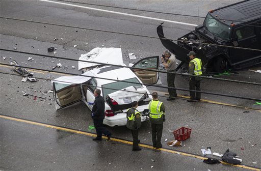 Los Angeles County Sheriff's deputies investigate the scene of a car crash where one person was killed and at least seven others were injured, Saturday, Feb. 7, 2015. Olympic gold medalist Bruce Jenner was in one of the cars involved in the four-vehicle crash on the Pacific Coast Highway in Malibu, California, that killed a woman, Los Angeles County authorities said.  AP PHOTO/RINGO H.W. CHIU