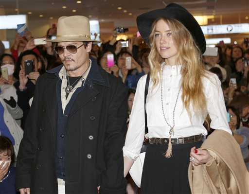 In this Jan. 26, 2015 file photo, U.S. actor Johnny Depp and Amber Heard arrive at Haneda international airport in Tokyo to promote his latest film "Mortdecai." Johnny Depp's wife Amber Heard has been charged with illegally bringing the couple's dogs to Australia. AP 