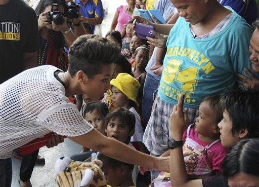 In this photo released by the Philippine Air Force, Grammy-winning singer Alicia Keys, left, touches a typhoon survivor as she visits the Villamor Air Base in suburban Pasay,. Keys visited the air force base to bring cheer to hundreds of evacuees from eastern Philippine provinces wracked by Typhoon Yolanda earlier this month. AP