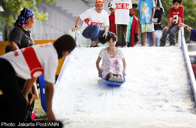 A girl plays in artificial snow at the Jak-Japan Matsuri event in Jakarta on Sunday. Jakarta Post/ANN