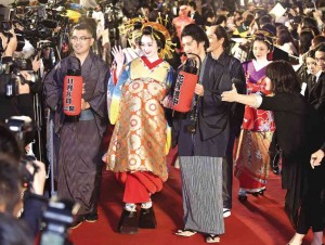 YUMI Adachi (center), in traditional kimono costume, is in “A Courtesan with Flowered Skin.”    AFP