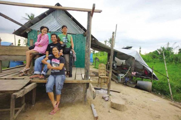 FILMMAKERS Wena Sanchez (left) and Cha Escala visit survivors Nick and Chai Quieta (center), in Tanauan, Leyte. The supertyphoon killed all of the couple’s four children, plus about a dozen relatives. 