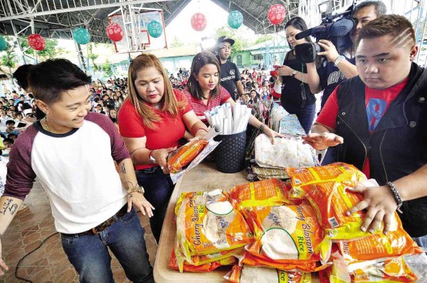 AT THE Cabuyao Central School (from left), Charice, mom Raquel, girlfriend Alyssa and brother Karl hand out gifts to fans. “I was a beauty queen here,” the singer told them. 