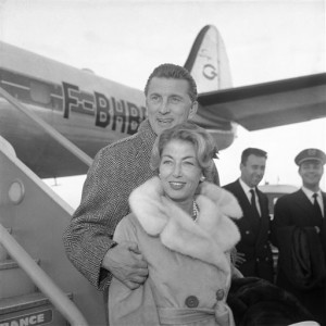 FILE - In this Dec. 5, 1960 file photo, actor Kirk Douglas and his wife Anne Douglas, formally Anne Buydens, arrive at London Airport from Paris to attend the premiere of his film, "Spartacus," in London. The “Spartacus” star, who just turned 98-years-old, has 87 films to his name, 11 books, and is one of the last living members of old Hollywood. His new poetry collection “Life Could Be Verse: Reflections on Love, Loss, and What Really Matters," in some ways, is his most personal work, featuring poems from throughout his life along with essays and private family photos that help paint a picture of him as a man, a father, and a husband. (AP Photo, File)