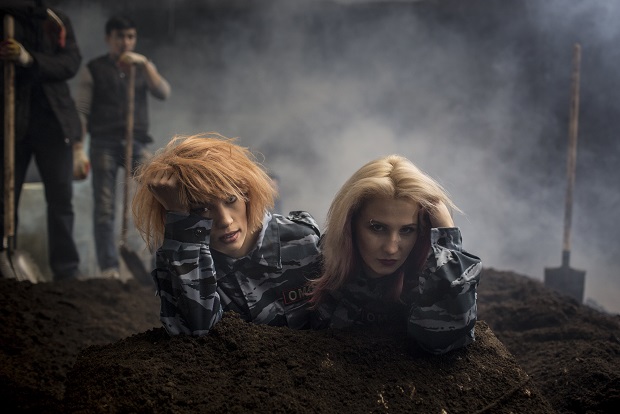 In this photo taken on Monday, Jan.  26, 2015,  two members of the punk band Pussy Riot, Maria Alekhina and Nadezhda Tolokonnikova, left, perform during their music video clip in Moscow, Russia. Two members of the punk provocateur band Pussy Riot have released a new music video dedicated to Eric Garner, an unarmed man who was killed when a New York City police officer put him in a fatal chokehold. In their video, Maria Alekhina and Nadezhda Tolokonnikova are dressed in Russian riot police uniforms and shown buried alive. The song is titled "I Can't Breathe," the last words of Eric Garner captured on video by a bystander. (AP Photo/Denis Sinyakov)