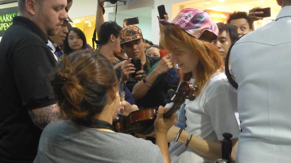Stirling signs a violin for a fan. Image by: Janine Villagracia/INQUIRER.net.