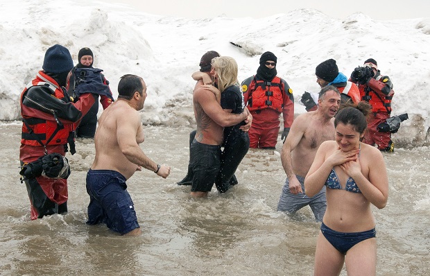 Actor Taylor Kinney, center left, holds his fiancée, pop star Lady Gaga, as they and members of the "Chicago Fire" cast take part in the Chicago Polar Plunge at North Avenue Beach on Sunday, March 1, 2015 in Chicago. (Photo by Barry Brecheisen/Invision/AP)