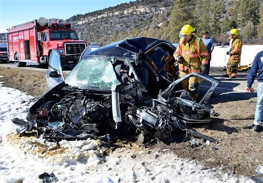 In this March 5, 2015 photo, Dolores Fire Protection District firefighters work at the scene of an accident near Dolores, Colorado. AP