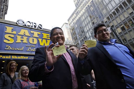 Audience members of the final taping of the CBS "Late Show with David Letterman" display their tickets as they leave the Ed Sullivan Theater in New York, Wednesday, May 20, 2015. Letterman signed off Wednesday after 33 years and 6,028 broadcasts of his late-night show. AP