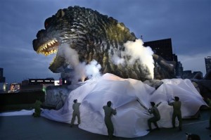 In this April 9, 2015 file photo, Godzilla's head is unveiled atop an office of Toho Co., the Japanese movie studio behind the 1954 original film of the irradiated monster, as it was appointed a special resident and tourism ambassador for Tokyo's Shinjuku ward during its awards ceremony in Tokyo. Toho is suing Voltage Pictures and director Nacho Vigalondo, complaining of copyright and trademark infringements in an upcoming film. Toho spokesman Makoto Hanari said Wednesday, May 20 that a lawsuit was filed Tuesday in a California court, but declined to discuss details.