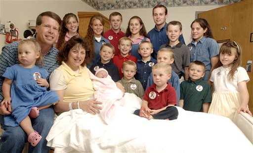 In this Aug. 2, 2007 file photo, Michelle Duggar, left, poses with her husband Jim Bob, second from left, and children, including their oldest son Josh, tallest standing, after the birth of her 17th child in Rogers, Ark. Calling himself "the biggest hypocrite ever," ex-reality star Josh Duggar has apologized for a "secret addiction" to pornography and for cheating on his wife he said in a statement posted Thursday, Aug. 20, 2015, on the family's website. The statement was apparently spurred by Duggar's name appearing among millions exposed in a data breach of customers of the Ashley Madison website, an online service that caters to men and women looking to cheat on their spouses.   AP FILE PHOTO