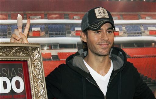 In this July 3, 2015 file photo, Enrique Iglesias flashes a V sign with his bandaged fingers during an interview at the National Auditorium in Mexico City. Following an accident with a drone that led to reconstructive hand surgery, Iglesias is giving a helping hand to children dealing with emergencies. Save the Children said Monday, Oct. 26, 2015, that Iglesias is working with the organization to sell white T-shirts with a red heart at its center - mirroring how Iglesias shirt looked after he cut his fingers at a concert and wiped the blood on his shirt.  AP PHOTO