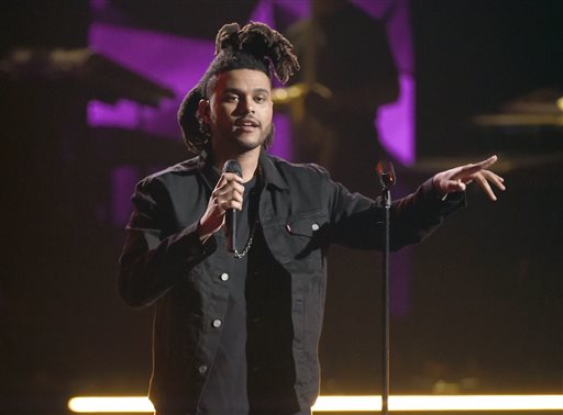 In this June 28, 2015 file photo, The Weeknd performs at the BET Awards in Los Angeles. The Weeknd, One Direction and Selena Gomez are among the acts slated to perform on the 11-date Jingle Ball tour this December. IHeartRadio announced Monday, Oct. 5, that the tour will kick off Dec. 1 in Dallas.The Dec. 11 show at New York’s Madison Square Garden will stream on Yahoo! and air as a 90-minute special on the CW Network on Dec. 17. (Photo by Chris Pizzello/Invision/AP, File)