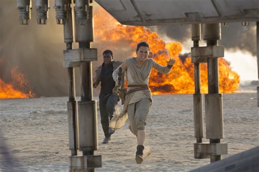 This photo provided by Disney/Lucasfilm shows Daisy Ridley, right, as Rey, and John Boyega as Finn, in a scene from the film, "Star Wars: The Force Awakens," directed by J.J. Abrams. Early screenings of the film begin Thursday night, Dec. 17, 2015. (David James/Disney/Lucasfilm via AP)