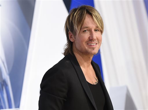 In a Wednesday, Nov. 4, 2015 file photo, Keith Urban arrives at the 49th annual CMA Awards at the Bridgestone Arena, in Nashville, Tenn. Urban is mourning the death of his father, Bob Urban, at the age of 73. Urban said in a statement released late Sunday, Dec. 6, 2015,  that his dad died on Saturday after a long battle with cancer. AP PHOTO