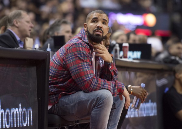 FILE - In this Nov. 25, 2015 file photo, Drake sits courtside during Drake night at the NBA basketball game between the Toronto Raptors and the Cleveland Cavaliers, in Toronto. The Canadian actor-singer and American actor-comedian will serve as the coaches for the Canada and USA teams at the NBA All-Star Celebrity Game on Feb. 12, 2016, at the Ricoh Coliseum in Toronto. (Darren Calabrase/The Canadian Press via AP, File)