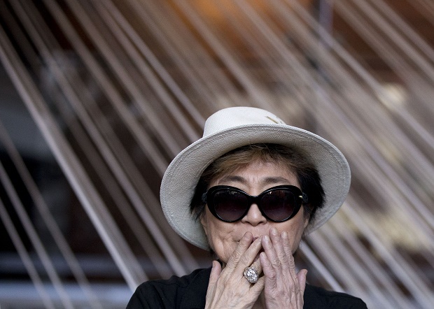 In this Tuesday, Feb. 2, 2016 photo, Yoko Ono blows a kiss as she poses for photographers in front of a work entitled, "Morning Beams/River Bed," at a press event to mark the opening of her exhibition, "Land of Hope" at the Museum of Memory and Tolerance in Mexico City. Bringing an anti-violence message to Mexico City, the 82-year-old Ono said, "I have come here to bring world peace." (AP Photo/Rebecca Blackwell)