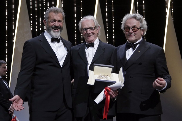 Director Ken Loach, centre, actor Mel Gibson, left and President of the Jury George Miller react after Roach is awarded the Palme d'or for the film I, Daniel Blake, during the awards ceremony at the 69th international film festival, Cannes, southern France, Sunday, May 22, 2016. (AP Photo/Thibault Camus)
