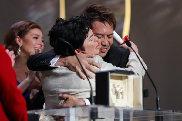 Filipino actress Jaclyn Jose (C) hugs Filipino director Brillante Mendoza after being awarded with the Best Actress prize during the closing ceremony of the 69th Cannes Film Festival in Cannes, southern France, on May 22, 2016. / AFP PHOTO / Valery HACHE