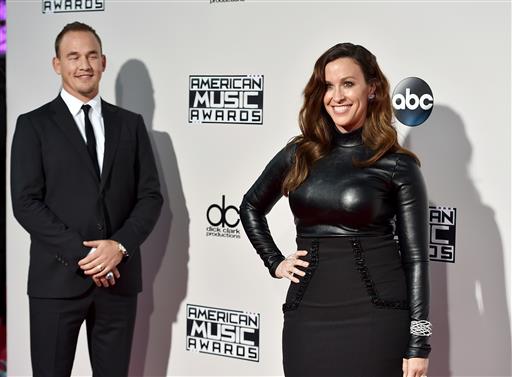 In this Nov. 22, 2015, file photo, Souleye, left, and Alanis Morissette arrive at the American Music Awards in Los Angeles. Morissette posted a nude photo of herself sporting a large baby bump while floating underwater on Instagram on June 28, 2016. AP