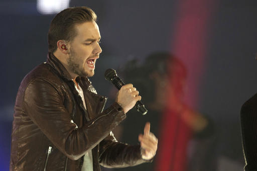 FILE - This is a Friday, Dec. 12, 2014 file photo of One Direction singer Liam Payne as he performs with the group, on stage during the ceremony of the '40 Principales Awards 2014' at Palacio de los Deportes in Madrid, Spain.  One Direction fans are seeing the writing on the wall as singer Liam Payne announced Friday July 22, 2016 that he has signed a record deal with Capitol Records UK after the boy band said last year they were taking a break. (AP Photo / Abraham Caro Marin, File)