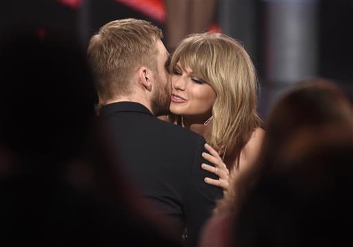 In this May 17, 2015 file photo, Taylor Swift, right, hugs Calvin Harris after winning the award for top billboard 200 album for "1989" at the Billboard Music Awards at the MGM Grand Garden Arena in Las Vegas. Swift has confirmed that she co-wrote ex-boyfriend’s Calvin Harris’ latest hit song under an alias, which prompted the DJ-producer to send a series of angry tweets Wednesday, July 13, 2016. AP/INVISION FILE PHOTO