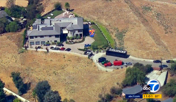 This image from aerial video provided by KABC-TV shows the home of entertainer Chris Brown with a police vehicle outside, in the Tarzana area of Los Angeles Tuesday, Aug. 30, 32016. Authorities waited for a search warrant outside Brown's Los Angeles home Tuesday after a getting a woman's call for help, officials said. Inside, the entertainer, who has a history of legal problems, posted videos to social media declaring his innocence. (KABC-TV via AP) MANDATORY CREDIT TV OUT