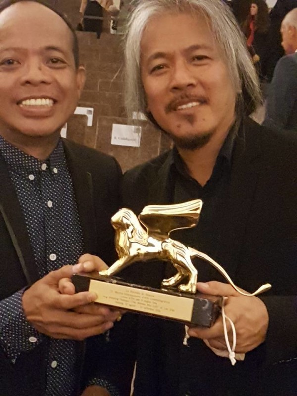 Lav Diaz and Cinema One Originals head Ronald Arguelles holding the Golden Lion Award