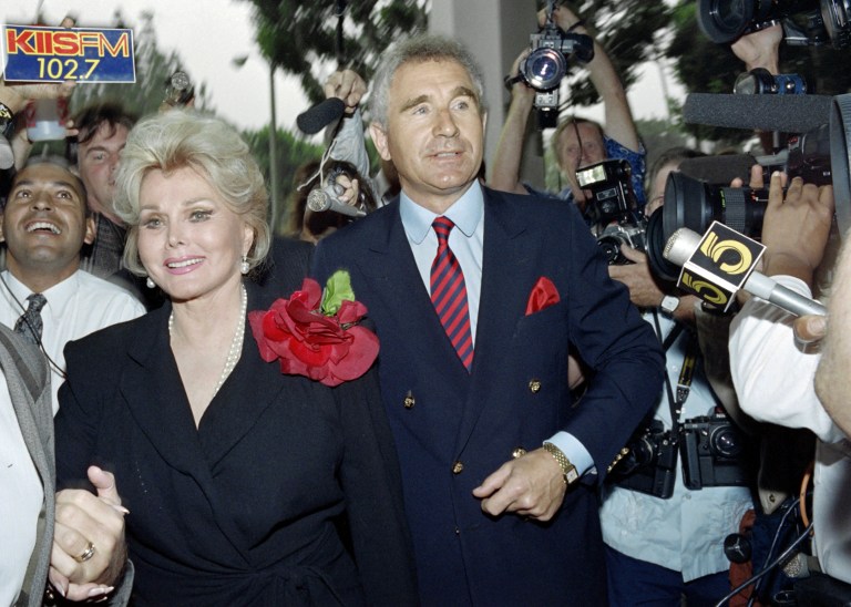 (FILES) This file photo taken on September 11, 1989 shows US actress Zsa Zsa Gabor and d by her husband Prince Frederick von Anhalt, Germany's duke of Saxony, entering Beverly Hills Municipal Court on September 11, 1989. She was charged with misdemeanor battery for slapping a traffic policeman who stopped had her Rolls Royce for expired registration tags.   Zsa Zsa Gabor, the Hungarian-born Hollywood siren perhaps better known for her prodigious love life than her movie credits, died Sunday, December 18, 2016 after suffering a heart attack, her husband said. An emotional Frederic von Anhalt told AFP that Gabor had passed away at home surrounded by friends and family. "Everybody was there. She didn't die alone," he told AFP by telephone, choking back sobs. She was 99. / AFP PHOTO / WADE BYARS