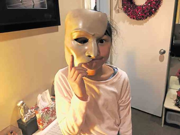 The author’s daughter Nicole, holding the iconic “Phantom” mask.