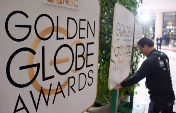 (FILES) This file photo taken on January 9, 2016 shows a worker adjusts signage in the arrivals area for the 73nd annual Golden Globe Awards, at the Beverly Hilton Hotel in Beverly Hills, California. Hollywood's elite hits the red carpet on January 8, 2017 for the 74th Golden Globes, launching a fiercely-contested awards season that looks set to reward escapist fantasy and gritty drama in equal measure.  / AFP PHOTO / ROBYN BECK