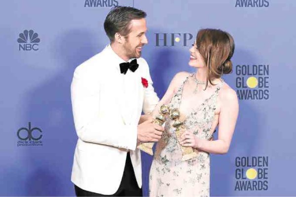 Ryan Gosling and Emma Stone let their trophies kiss. —JOHN SALANGSANG