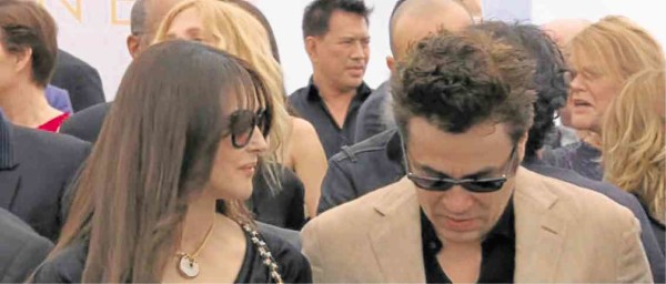 Brillante Ma Mendoza stands behind Monica Bellucci and Benicio Del Toro at the 70th anniversary photo call.  