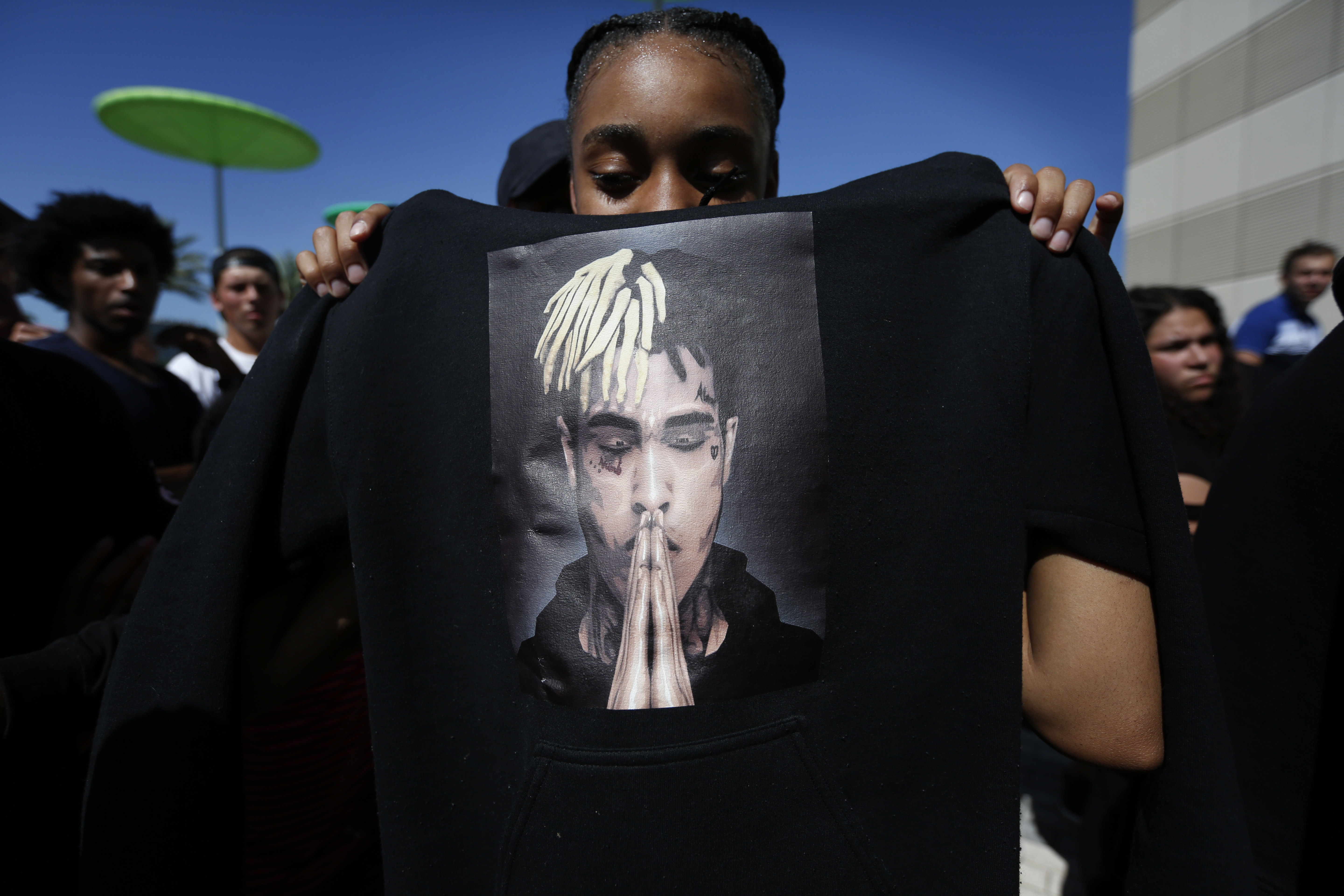 ...14, of St. Petersburg, Fla., holds up a sweatshirt with an image of slai...