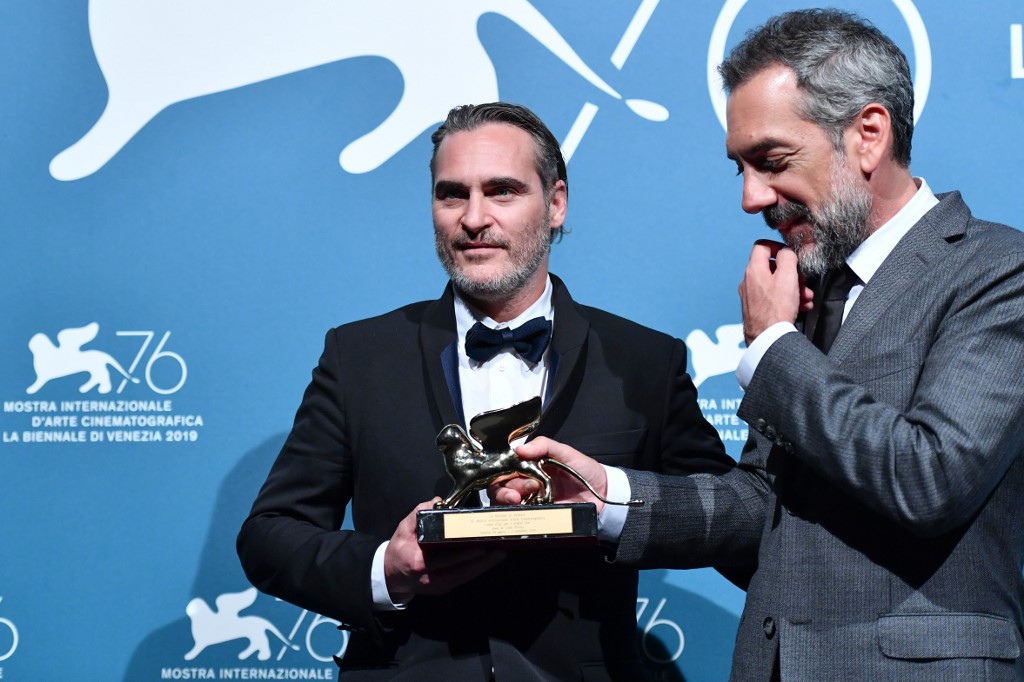US director Todd Phillips (R) and US actor Joaquin Phoenix, hold the Golden Lion award for Best Film that Philipps received for the movie "Joker" during the awards ceremony winners photocall of the 76th Venice Film Festival on September 7, 2019 at Venice Lido. (Photo by Alberto PIZZOLI / AFP)