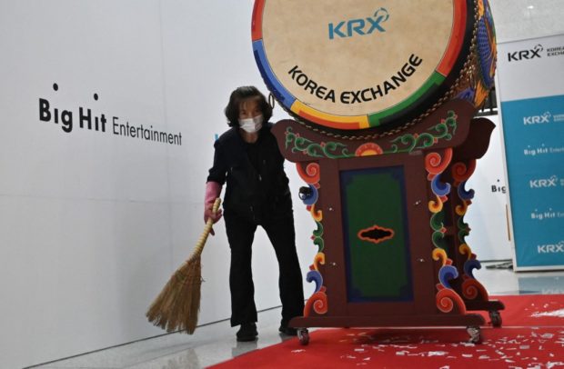 A cleaning staff sweeps up after an initial public offering ceremony of K-pop management agency Big Hit Entertainment, who manage K-pop sensation BTS, at the lobby of the Korea Exchange in Seoul on October 15, 2020