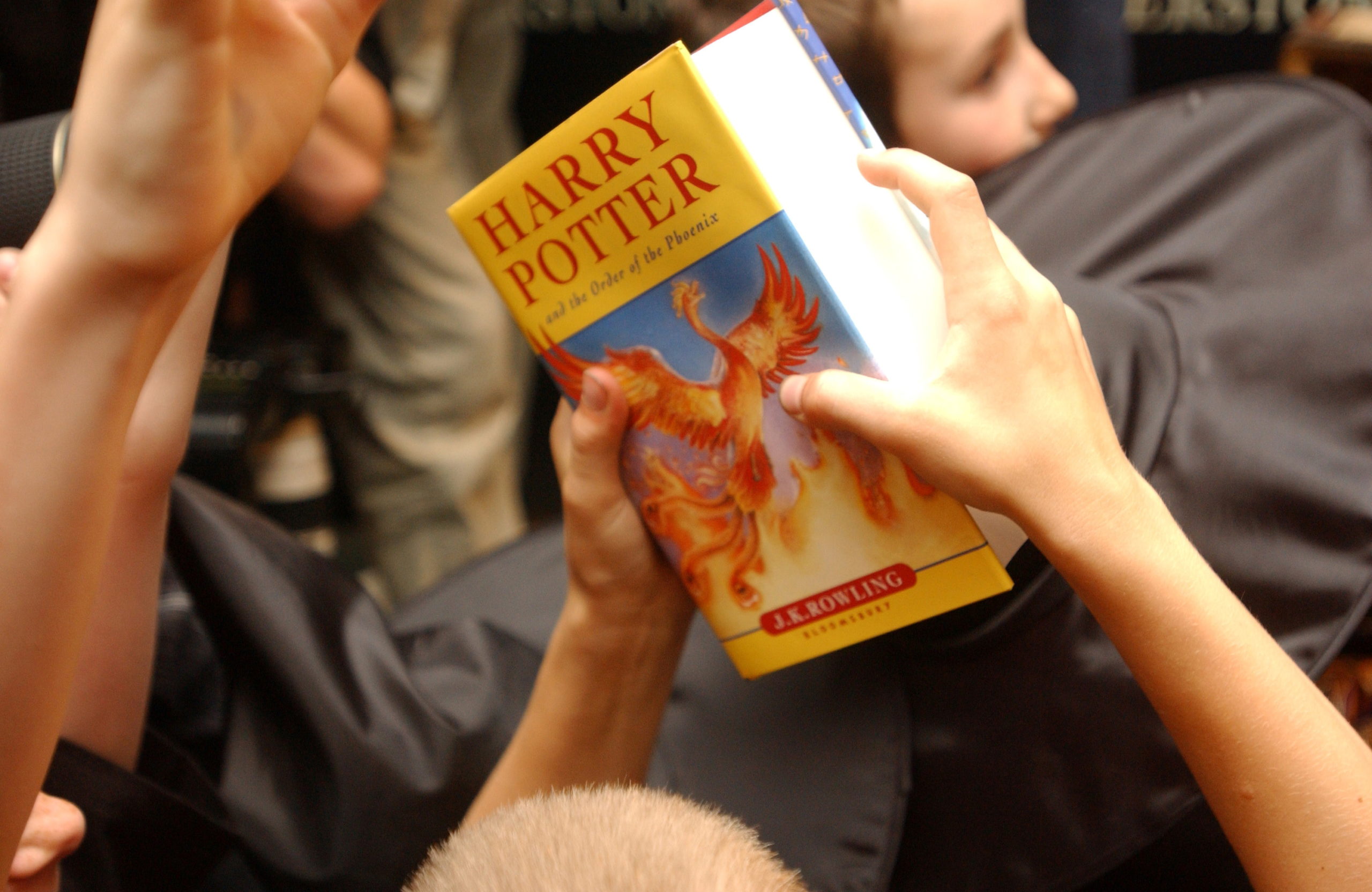 A child holds a copy of "Harry Potter and the Order of the Phoenix," at Waterstone's bookshop in central London 21 June, 2003 REUTERS/Sinead Lynch/File Photo
