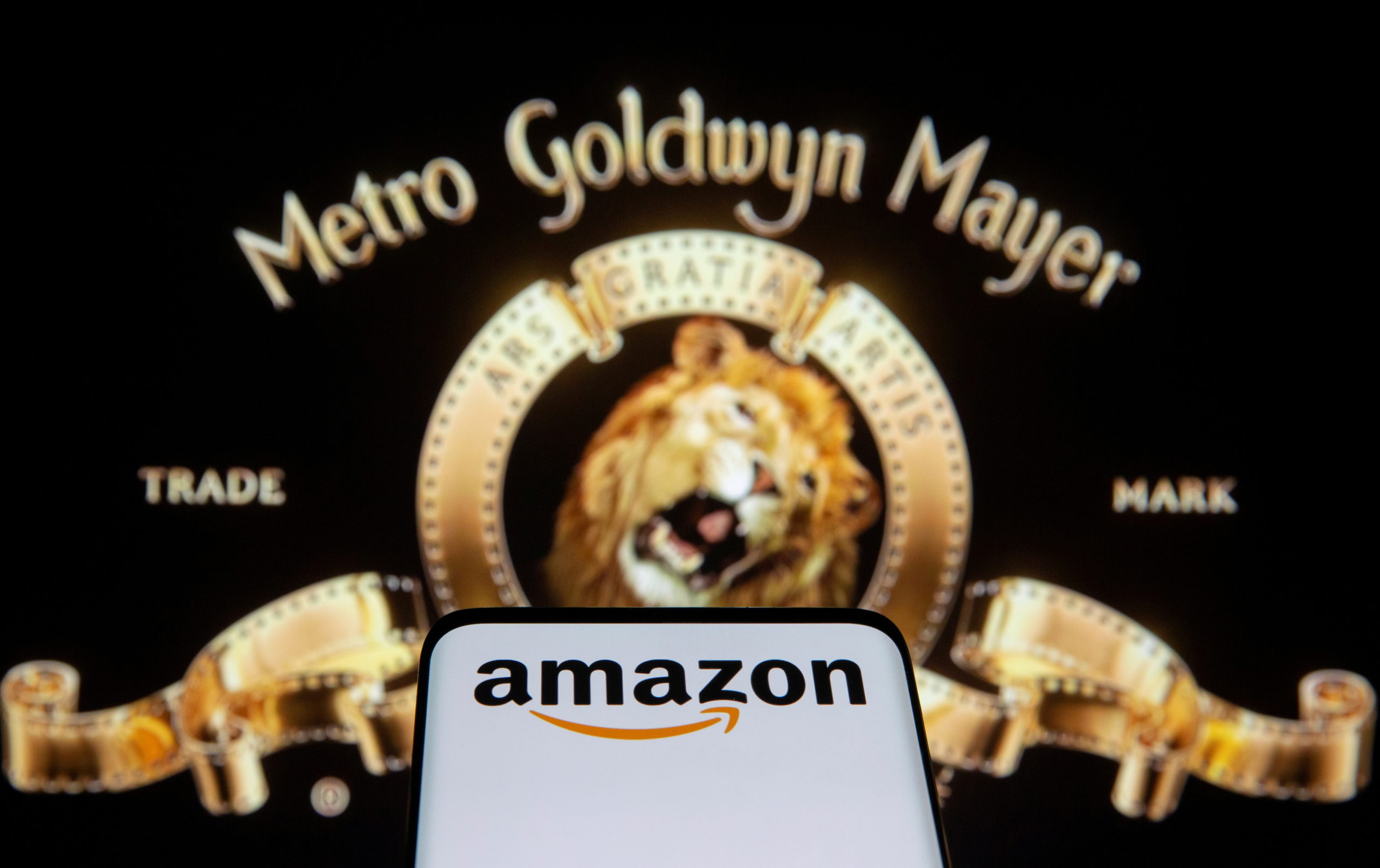 Smartphone with Amazon logo is seen in front of displayed MGM logo in this illustration taken, May 26, 2021. REUTERS/Dado Ruvic/Illustration