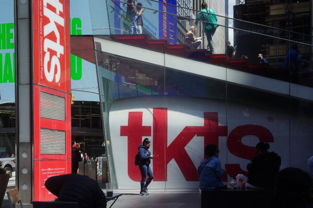People walk past the tkts booth on Broadway in New York City