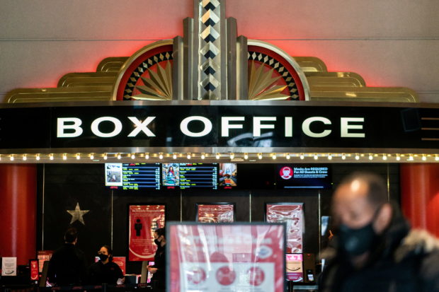 A guest purchases a ticket in front of a box office at AMC movie theatre in Lincoln Square, amid the coronavirus disease (COVID-19) pandemic, in the Manhattan borough of New York City, New York, U.S., March 6, 2021. REUTERS/Jeenah Moon/File Photo