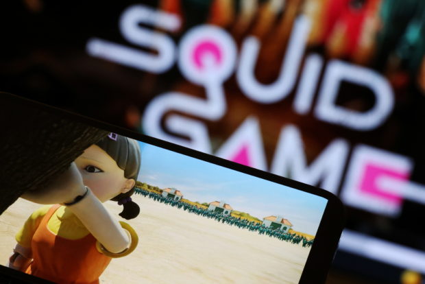 The Netflix series "Squid Game" is played on a mobile phone in this picture illustration taken September 30, 2021. REUTERS/Kim Hong-Ji/Illustration