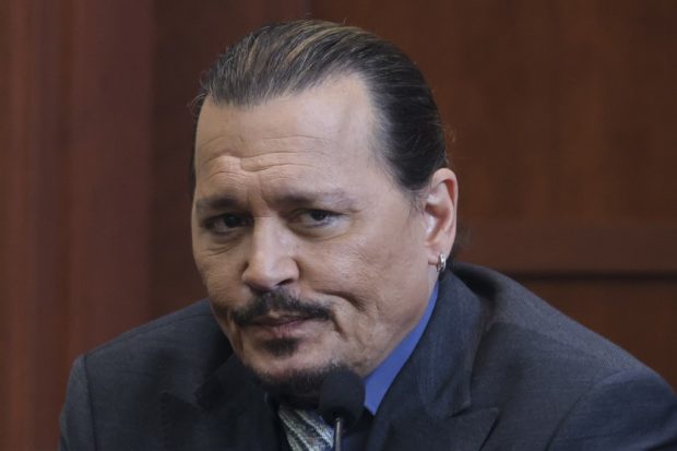Actor Johnny Depp reacts as he testifies in the courtroom during his defamation trial against his ex-wife Amber Heard, at the Fairfax County Circuit Courthouse in Fairfax, Virginia, on May 25, 2022. - Actor Johnny Depp is suing ex-wife Amber Heard for libel after she wrote an op-ed piece in The Washington Post in 2018 referring to herself as a public figure representing domestic abuse. (Photo by EVELYN HOCKSTEIN / POOL / AFP)
