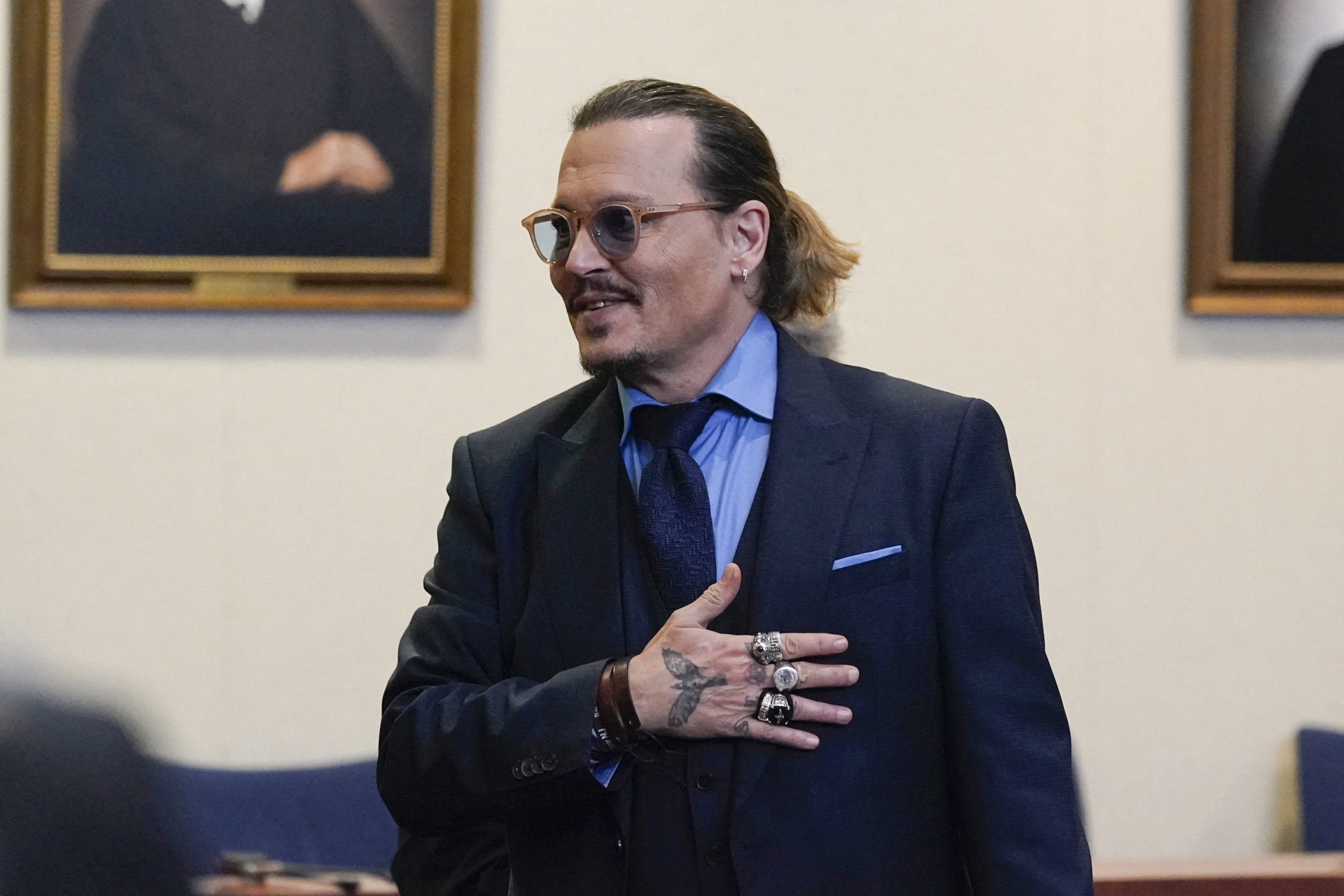 Actor Johnny Depp gestures to spectators in court after closing arguments at the Fairfax County Circuit Courthouse in Fairfax, Virginia. - A US jury found June 1, 2022 that actress Amber Heard had made defamatory claims of abuse against her ex-husband Johnny Depp, and awarded him $15 million in damages. (Photo by Steve Helber / POOL / AFP)