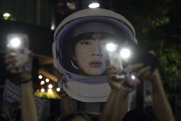 Fans of South Korean K-Pop boy band unable to attend the show, gather outside the River Plate's Monumental stadium to listen to Kim Seok-jin -aka Jin- perform his single solo "The Astronaut" with British rock band Coldplay, during the third of ten concerts of their "Music of the Spheres" world tour, in Buenos Aires, on October 28, 2022. (Photo by JUAN MABROMATA / AFP)