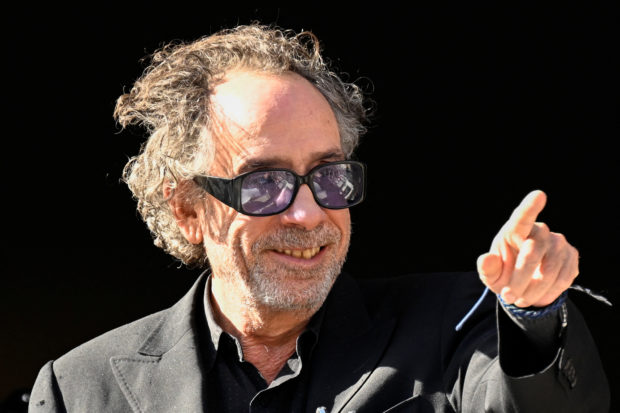 Film director Tim Burton greets fans from a balcony during the Lucca Comics and Games for the premiere of Netflix's new series 'Wednesday' in Lucca, Italy, October 31, 2022. REUTERS/Flavio Lo Scalzo