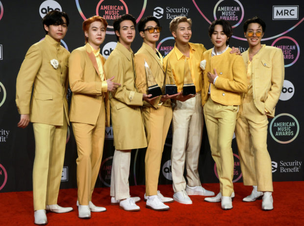 FILE PHOTO: Jin, Suga, V, Jungkook, RM, Jimin, and J-Hope of BTS hold their award for the Favourite Pop Song, Favourite Duo or Group and Artist of the Year awards while posing in the press room during the 2021 American Music Awards at the Microsoft Theater in Los Angeles, California, U.S., November 21, 2021. REUTERS/Aude Guerrucci