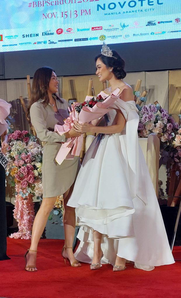 Miss International 2005 Precious Lara Quigaman, now Bb. Pilipinas Charities Executive Committee member, hands over to Hannah Arnold before her flight to Tokyo./ARMIN P. ADINA