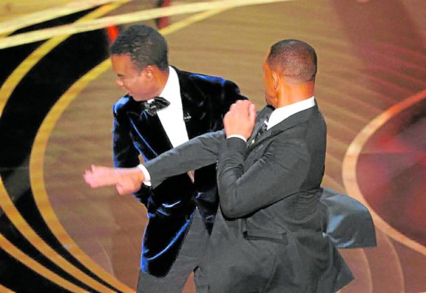 FILE PHOTO: Will Smith (R) hits Chris Rock as Rock spoke on stage during the 94th Academy Awards in Hollywood, Los Angeles, California, U.S., March 27, 2022. REUTERS/Brian Snyder