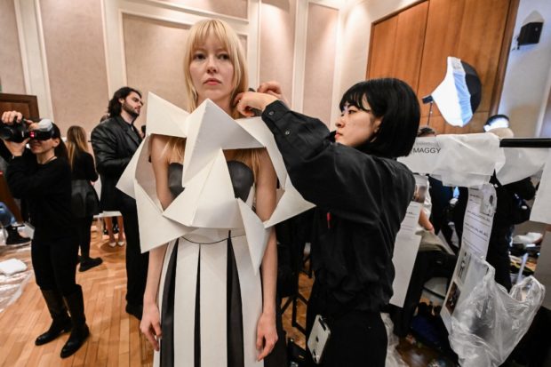 A model is being dressed backstage prior to the presentation of Atsushi Nakashima's Fall-Winter 2023-2024 Women's collection, on February 26, 2023 during the  Fashion Week in Milan. (Photo by Miguel MEDINA / AFP)